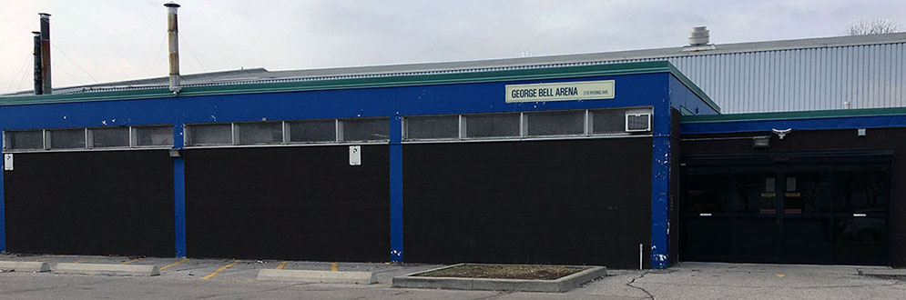 The exterior of George Bell Arena, which is painted blue and has a garage-like appearance.