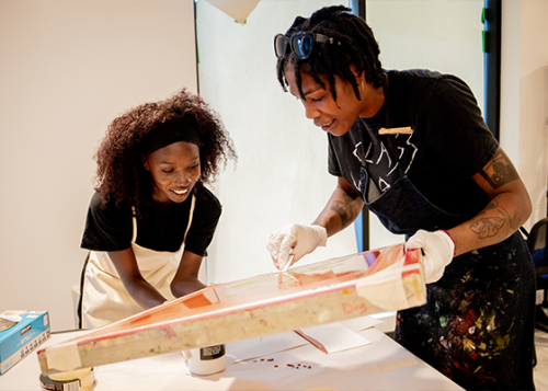 Two artists working together to create a print.