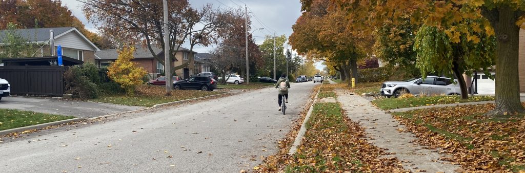 A person cycling on the street in the Bathurst Manor neighbourhood