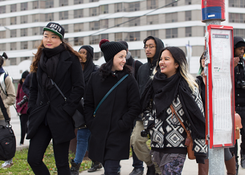 A group of people waiting at a bus stop.