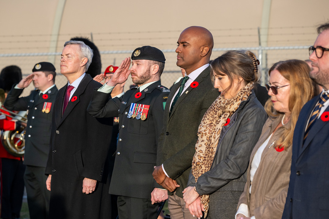 Six members of the official party standing in a moment of reflection