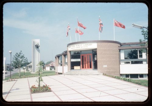 Image depicts colour photographs of library building with public art sculpture in background, and paved forecourt in foreground