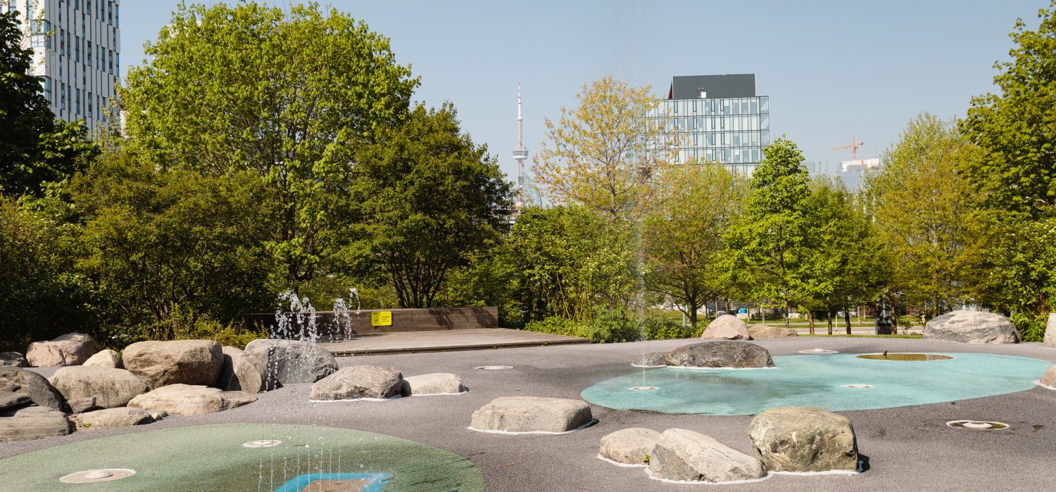 Corktown Common Splash Pad with a view of the CN Tower in the background