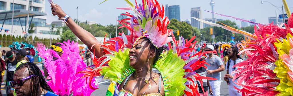 Smiling woman wearing Caribbean Carnival costume in crowd