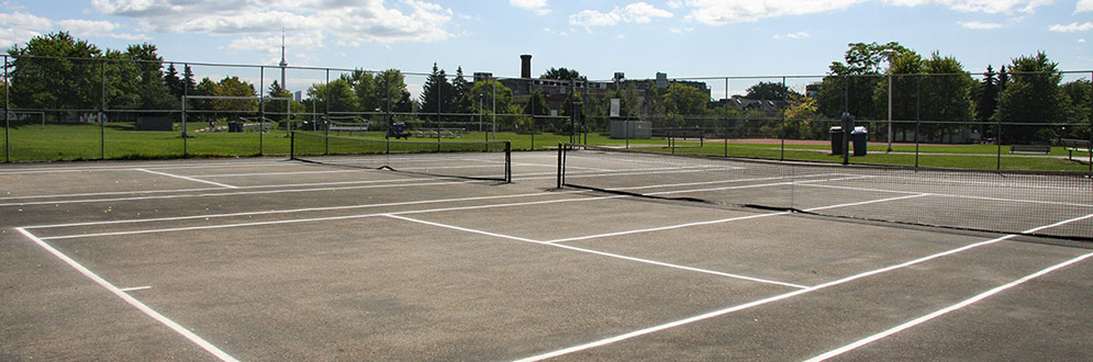 Two tennis courts side by side, fenced in.