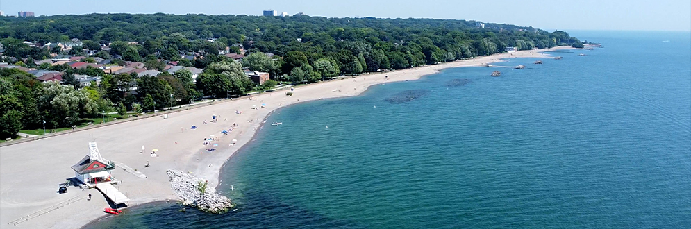 Kew-Balmy Beach on a summer day with people swimming the water and lifeguards on duty.