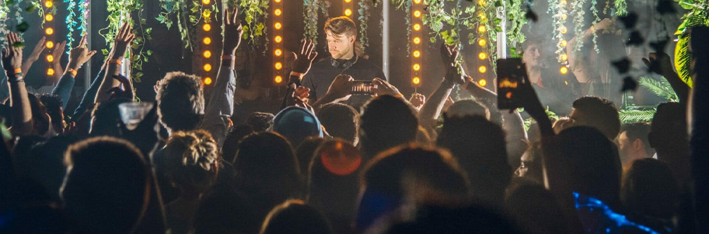 Man performs on a stage with crowd in foreground