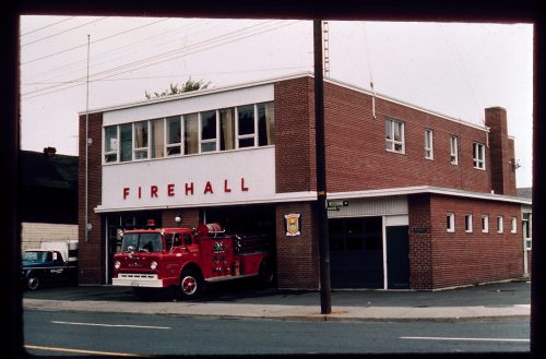 Image depicts colour photograph of fire engine leaving fire station