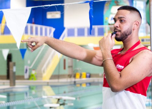 A lifeguard is whistling at the indoor pool