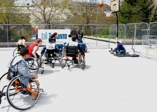 Playing wheelchair basketball game at the outdoor court.