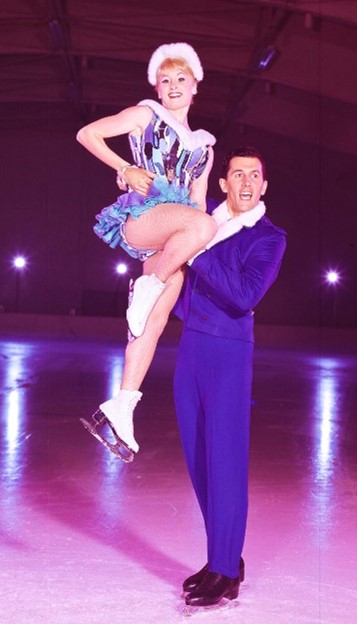 Paulette and Ken dressed in their skating outfit, Paulette held by Ken on the ice 