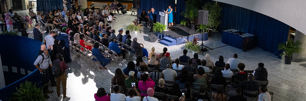 People seated around a small stage watching a presentation