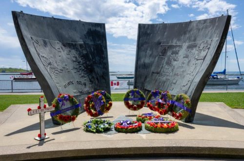 Monument in the shape of the bow of a ship with wreaths laid at the bottom