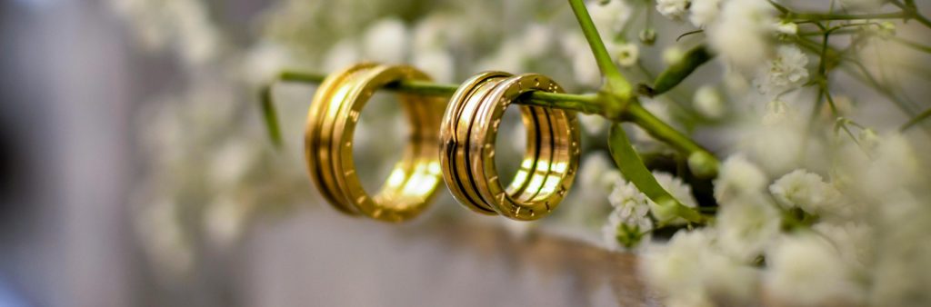 Two golden rings next to flowers
