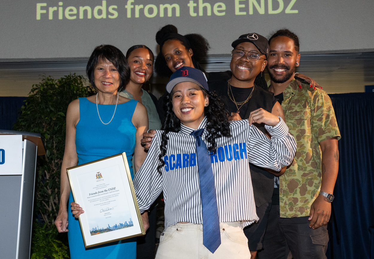 A group of people smiling for the camera with Mayor Olivia Chow holding up a framed award.