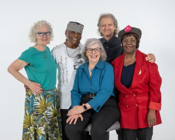A group of seniors standing in front of a white backdrop posing for the camera.