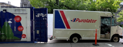 Delivery truck unloading packages into the back doors of an On-Street Logistics Mini Hub 