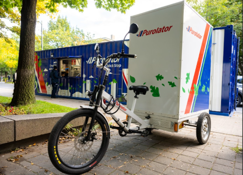 An image of a bicycle with a Purolator storage unit on the back to carry packages. 