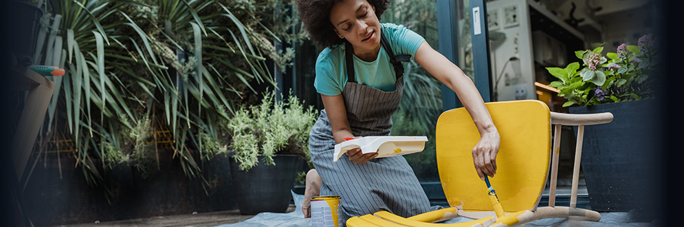 Woman painting chair to extend its life