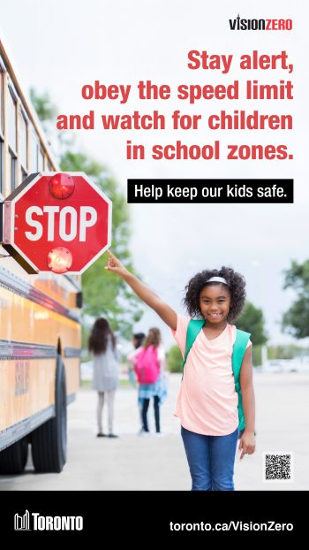 Image of a child pointing to the stop sign on a school bus