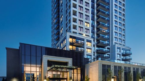Front entrance of 10 Eva Road, black and white rectangular front entrance and condominium towers.