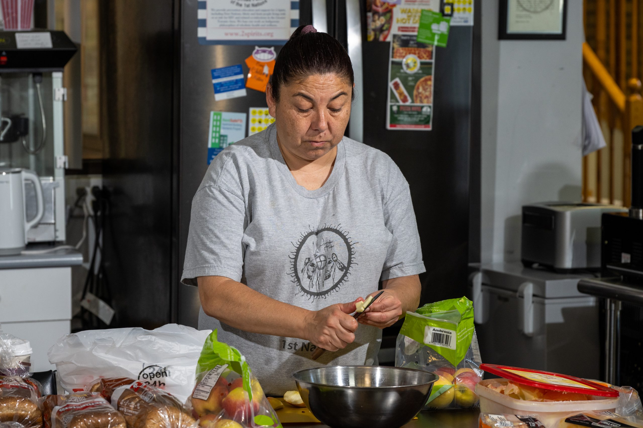 A woman cutting up apples in a kitchen.