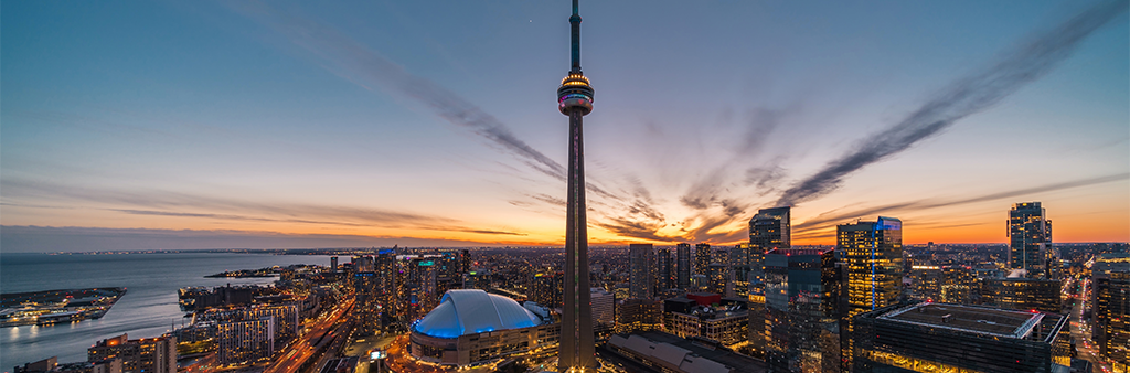 An aerial view of downtown Toronto at Sunset facing the CN Tower with the Lake Ontario in the background.