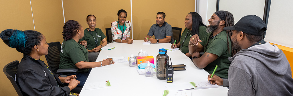 A group of people sitting around a table in a boardroom.