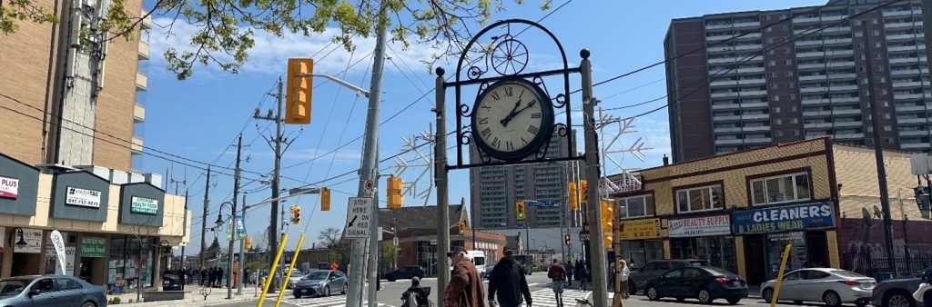 A clock on a pole in a city.