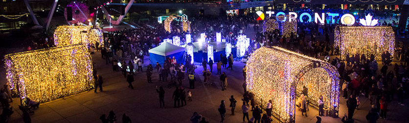 photo of outside special event at Nathan Phillips Square as people walk and visit different booths and activations.