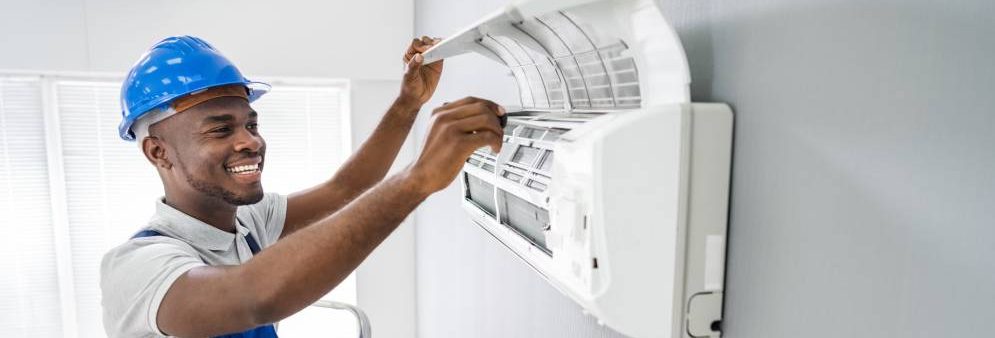 A colour image of an HVAC professional installing a heat pump inside of a living room