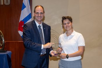 Toronto City Manager poses with Emily Akerman receiving an award.