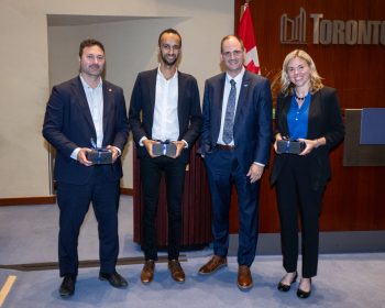 Toronto City Manager poses with a group of people receiving an award.