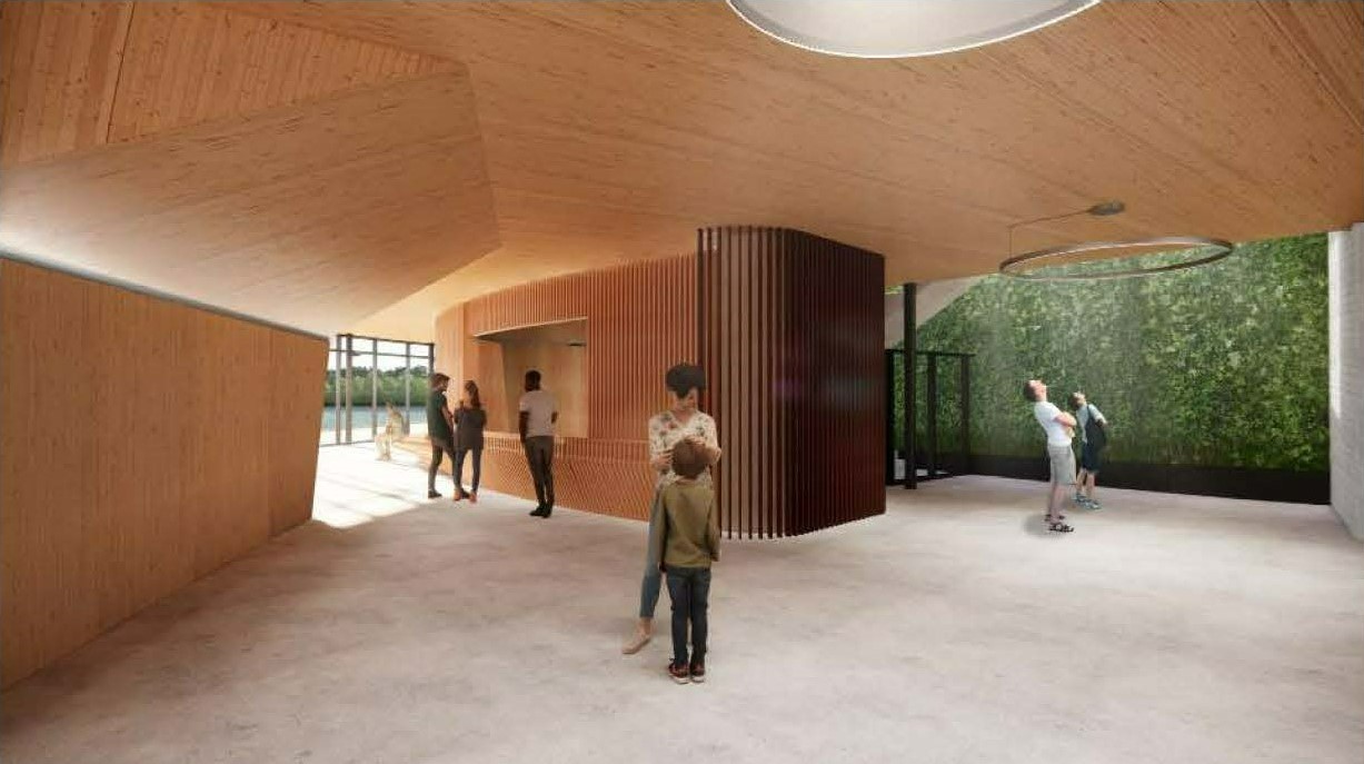Rendering of a flexible use space in the recreation building. The open-plan interior has concrete floors and wood finishes on the walls and ceiling. At one end, a wall is covered in green vegetation, and a large circular light hangs from the ceiling. In the centre of the space, a partial partition made of dark brown wooden slats connects to a reception area made of light brown wooden slats. Visible in the background are floor-to-ceiling windows that overlook a terrace and pond.