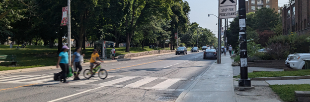 Rendered image of two people walking and one person on a bike crossing Davisville Avenue