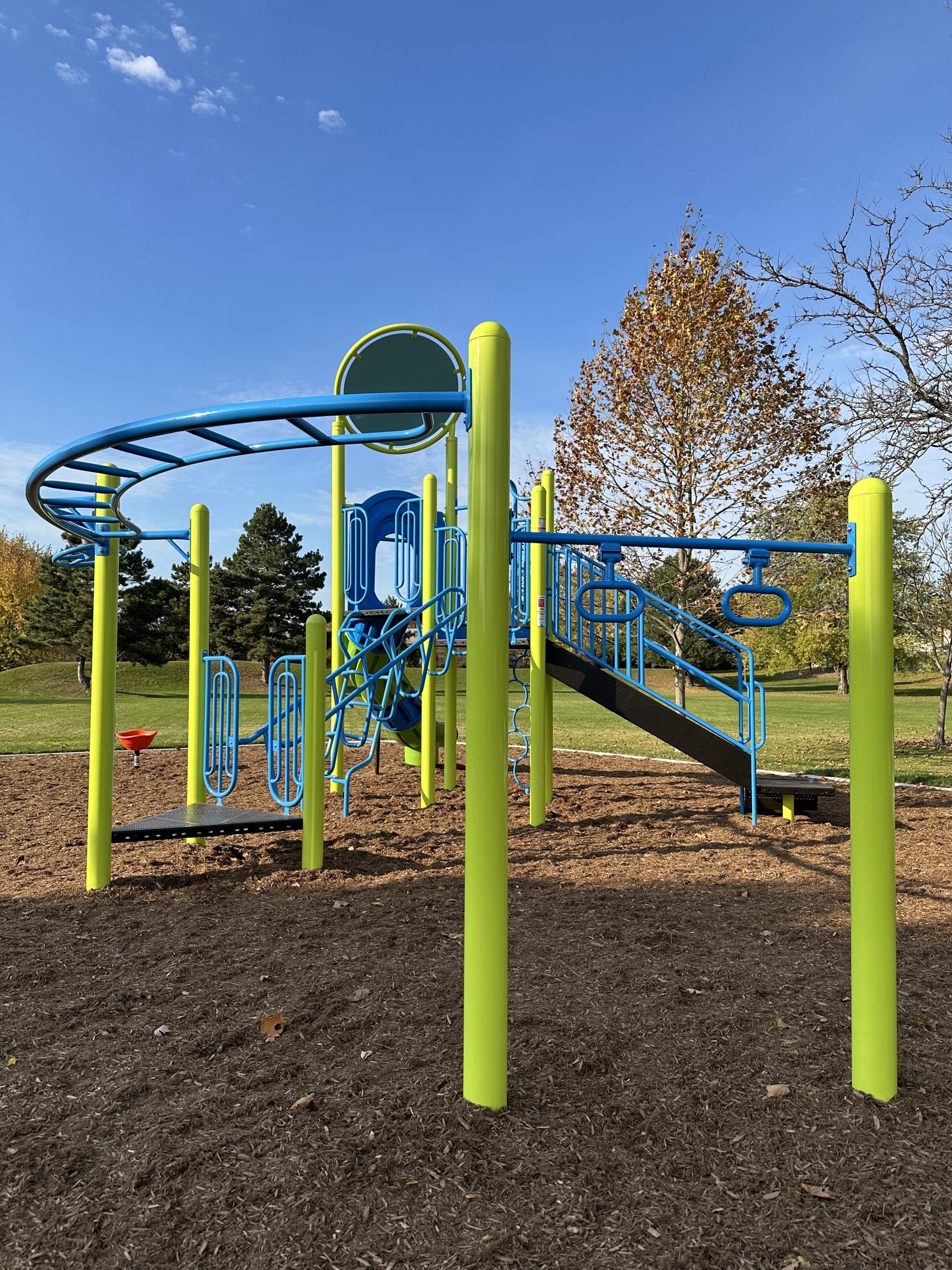 The senior play structure with climbing elements, hanging features like monkey bars, and a slide.