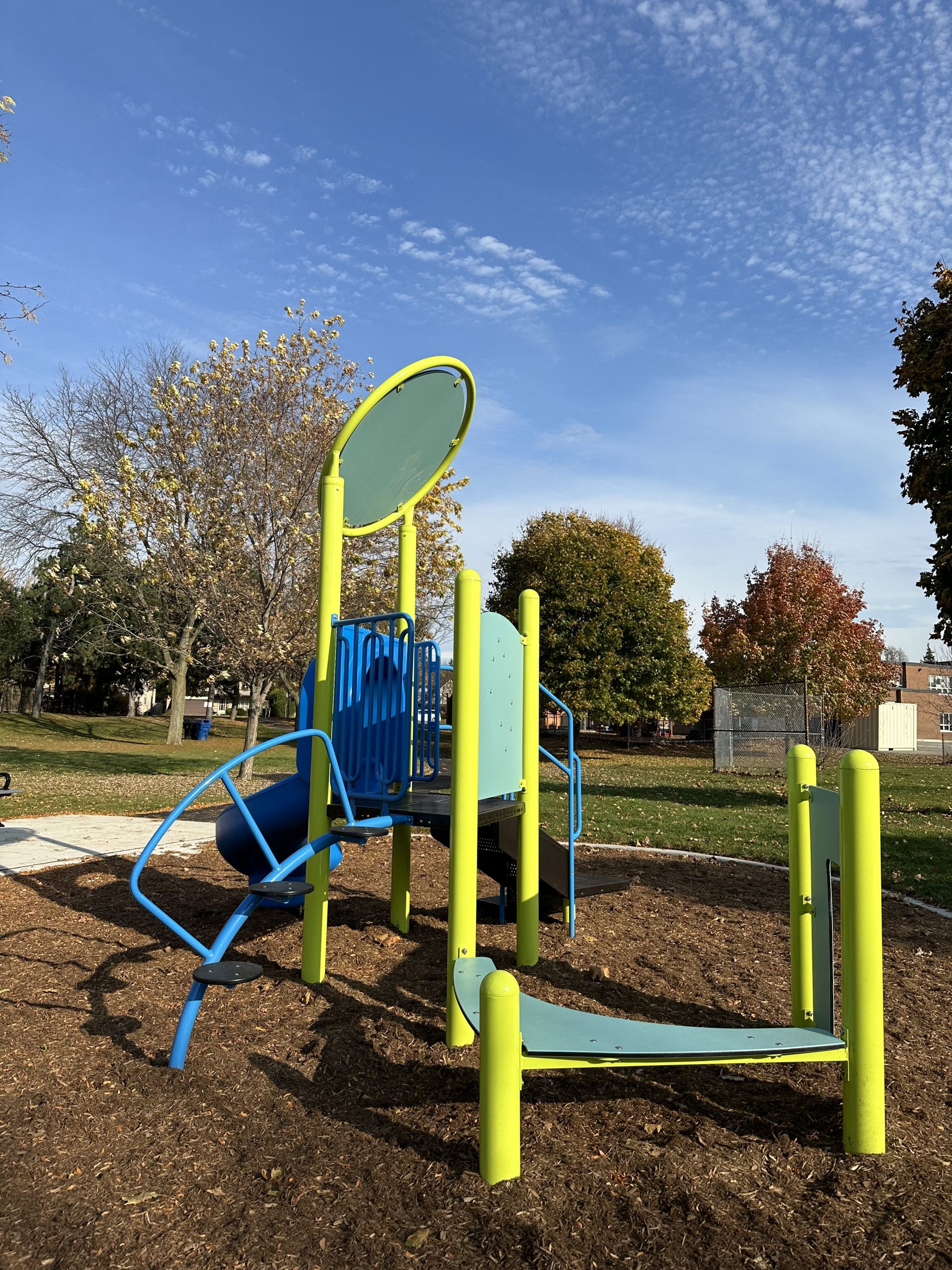 The junior play structure featuring climbing elements, play panels, and a slide.
