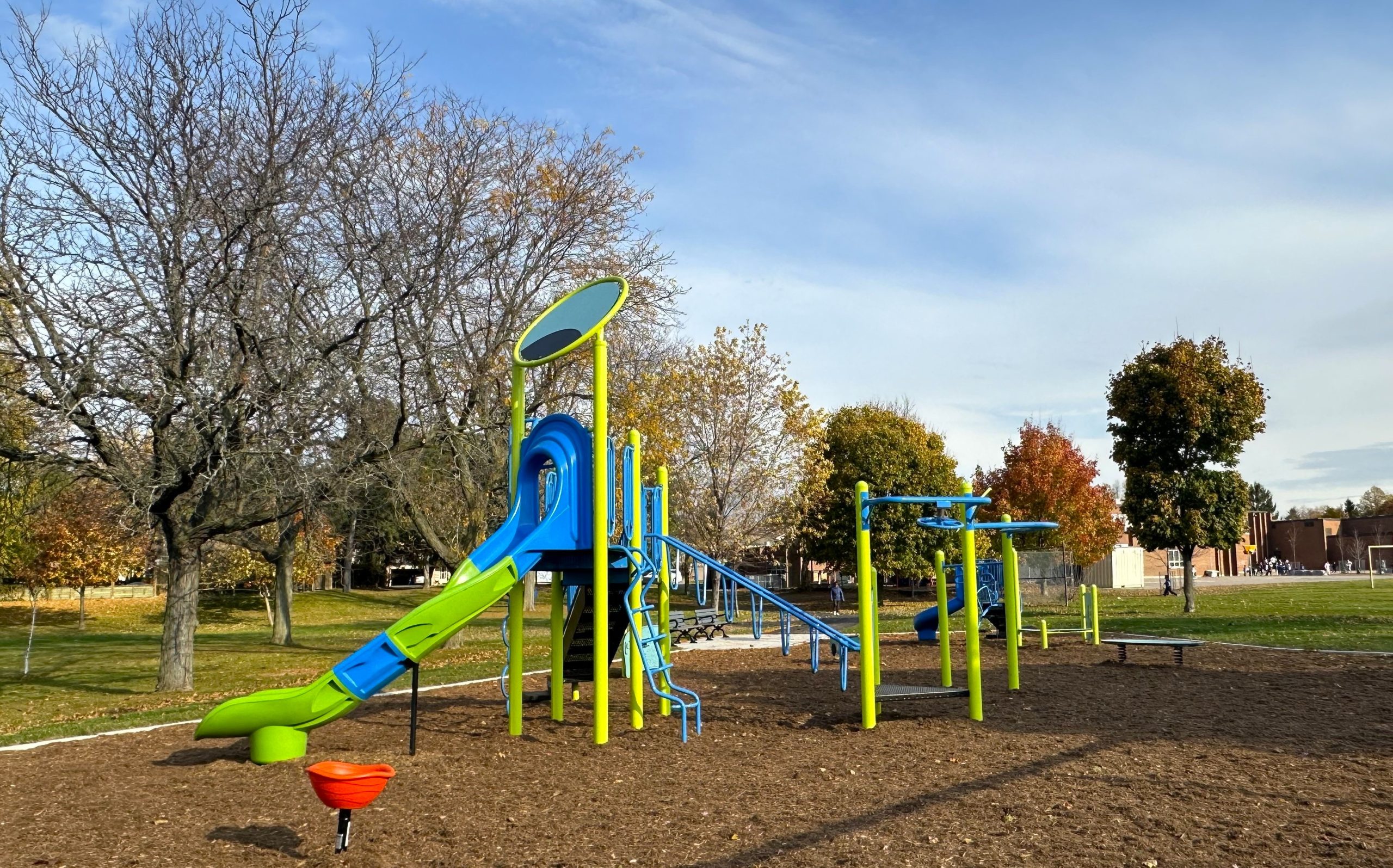 The senior play structure in the foreground, with the junior play structure positioned in the background and springer toys spread throughout the playground.