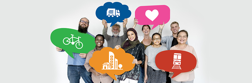 A group of diverse people standing together and holding thought bubble cutouts with different icons. Icons are a heart, a truck, a bike, a group of buildings and a subway train.