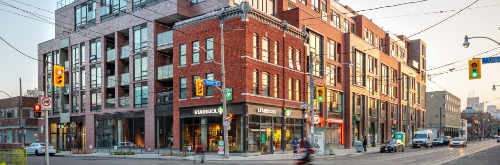 An image of a 7-storey mid-rise building that complements the street's scale and incorporates a preserved heritage building. The building's articulated façade, along with shops and restaurants, complements the character of the area, activates the public realm, and creates a vibrant streetscape.