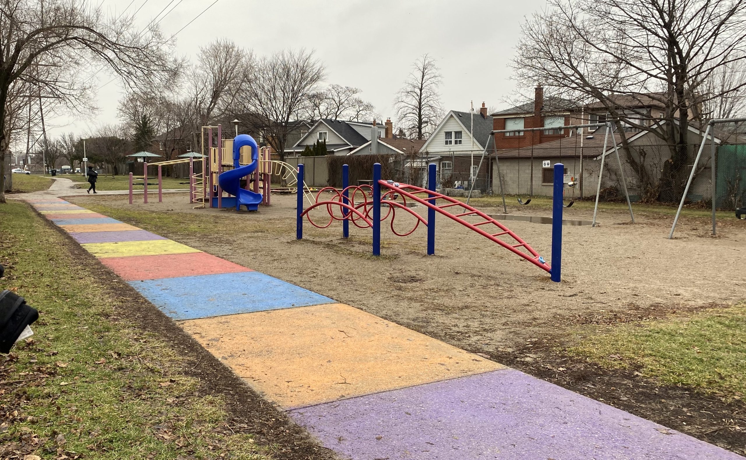 The old S.A.D.R.A. Park playground including: a large play structure with slides, platforms and climbers on the right-back, a low climbing structure centre fore-ground, and the swing-set to the left-back.