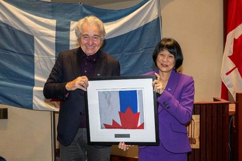 Mayor Olivia Chow gifts original flag designer Rene DeSantis with the flag flown at City Hall on 50th anniversary of its first hoisting