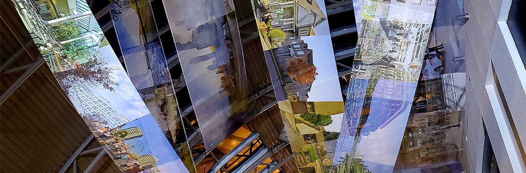 Long cloth banners covered in photographs like a reel of film drapes from the ceiling of a building