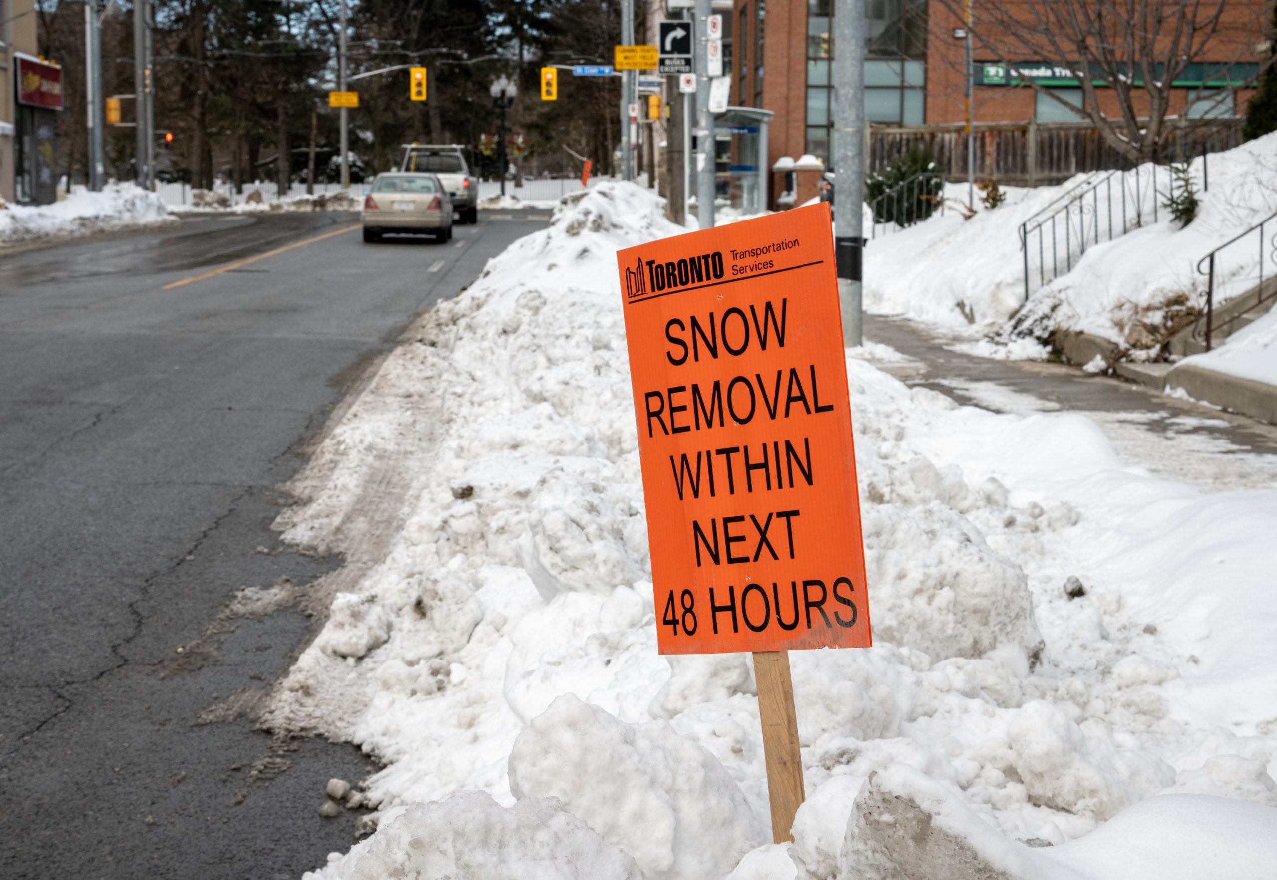 Temporary sign in snow bank that reads - snow removal within next 48 hours.