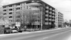Car lot with apartment buildings next to it.