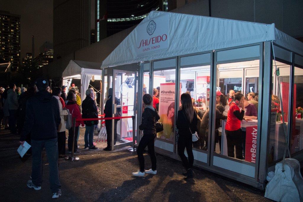 People line up at the illuminated Shiseido Share Beauty activation tent