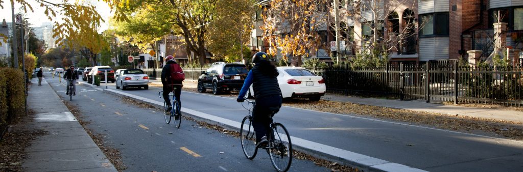 People cycle in a two-way cycle track on Wellington Street West.