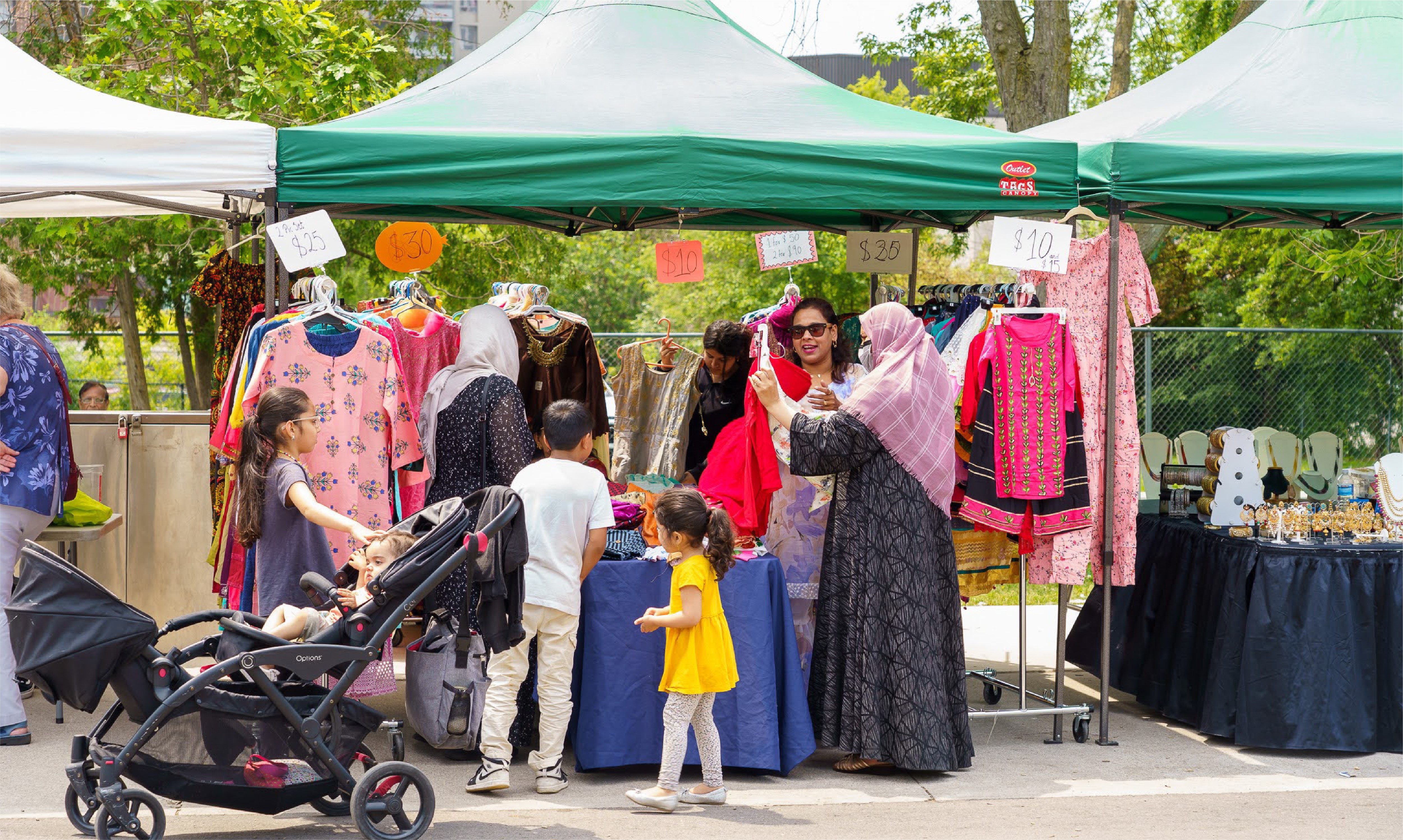 People shopping at an outdoor bazaar on a sunny day.