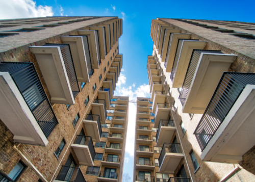 A worm's eye view of apartment complexes against a blue sky.