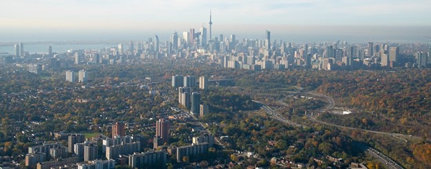 Photograph of the city of Toronto looking south, with residential neighbourhoods in the foreground and the city’s downtown skyline in the background.
